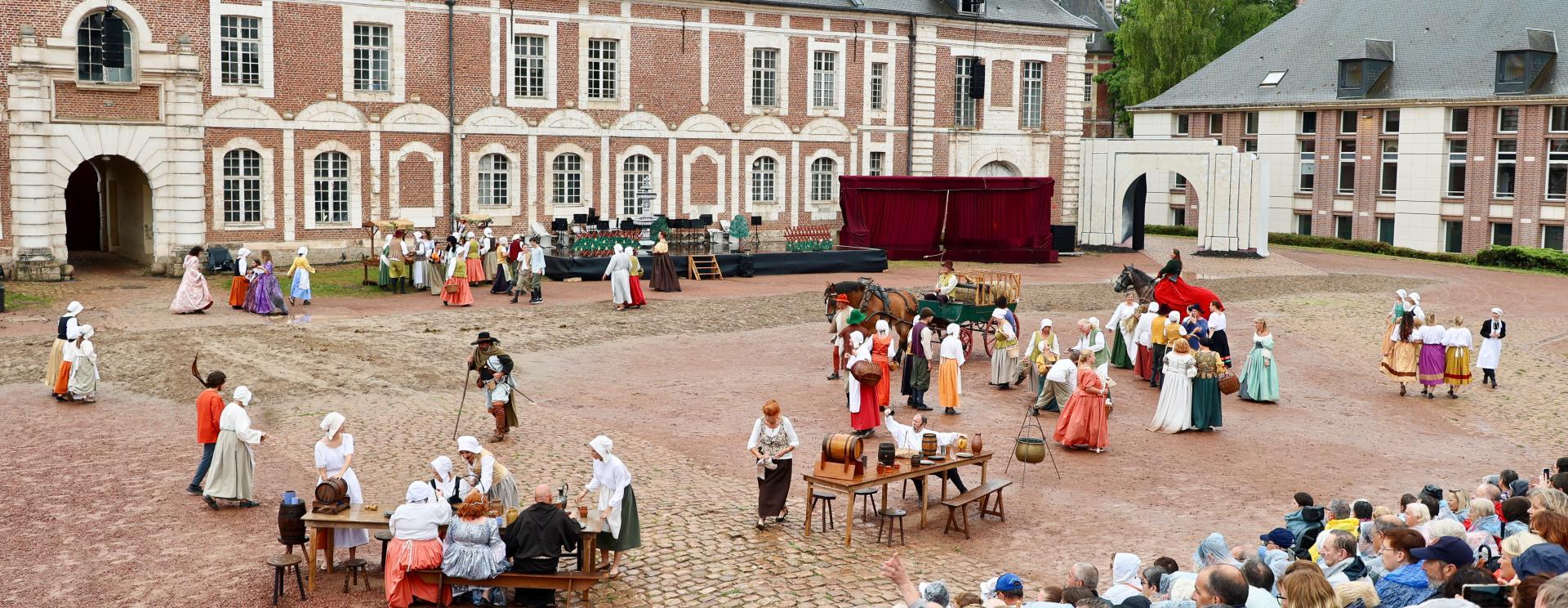 spectacle avec spectateurs dans les gradins, sur une place