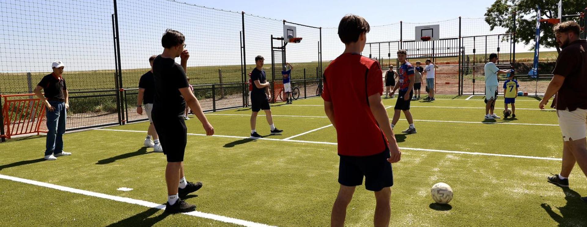 enfant jouant au ballon sur un city-stade