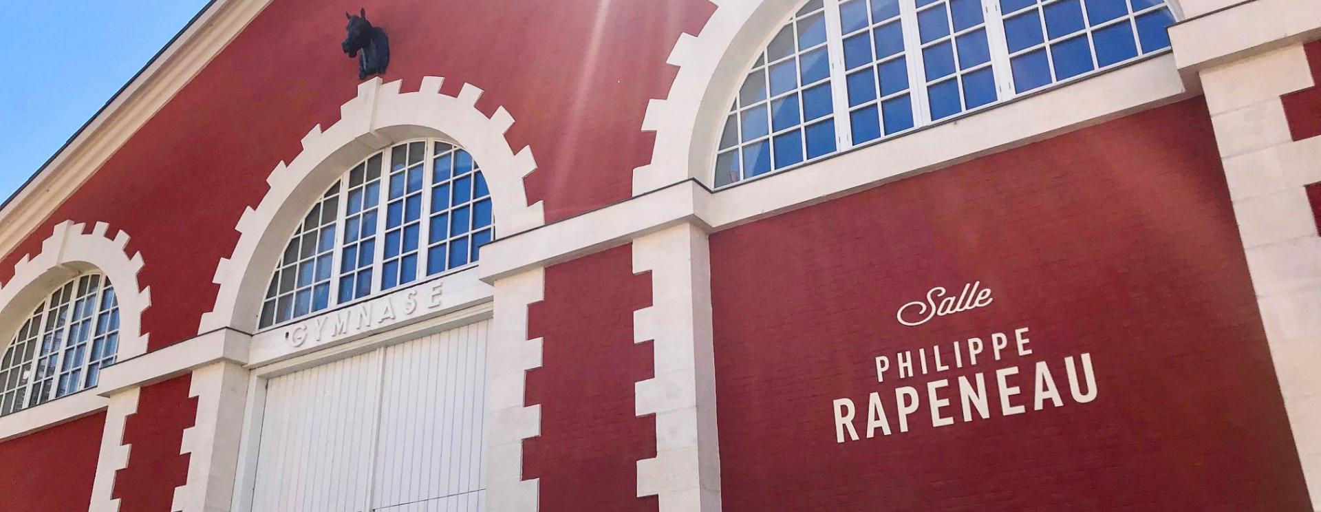 bâtiment en brique rouge portant l'inscription salle Philippe Rapeneau