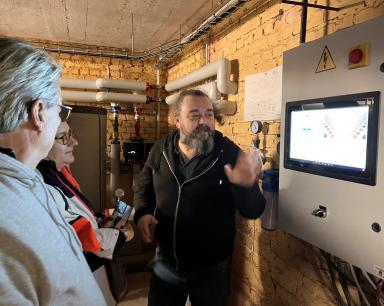 3 personnes devant le panneau de contrôle du réseau de chaleur