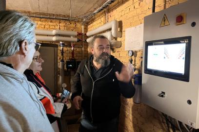 3 personnes devant le panneau de contrôle du réseau de chaleur - Agrandir l'image, fenêtre modale