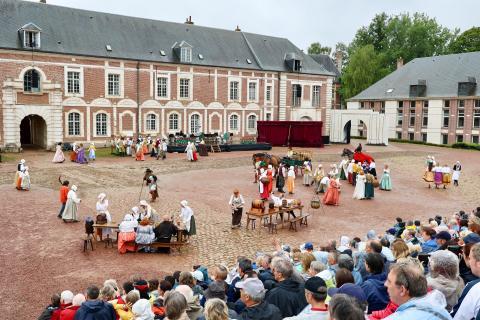 spectacle avec spectateurs dans les gradins, sur une place