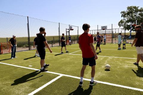 enfant jouant au ballon sur un city-stade
