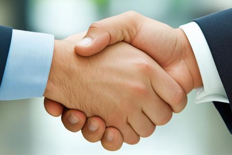 poignée de mains entre deux personnes en costume