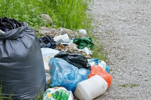 sac poubelle et déchets au bord d'une route