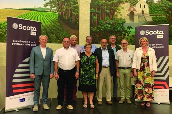 des personnes posant devant des pancartes SCOTA le meilleur est à venir, partageons notre avenir - Agrandir l'image, fenêtre modale